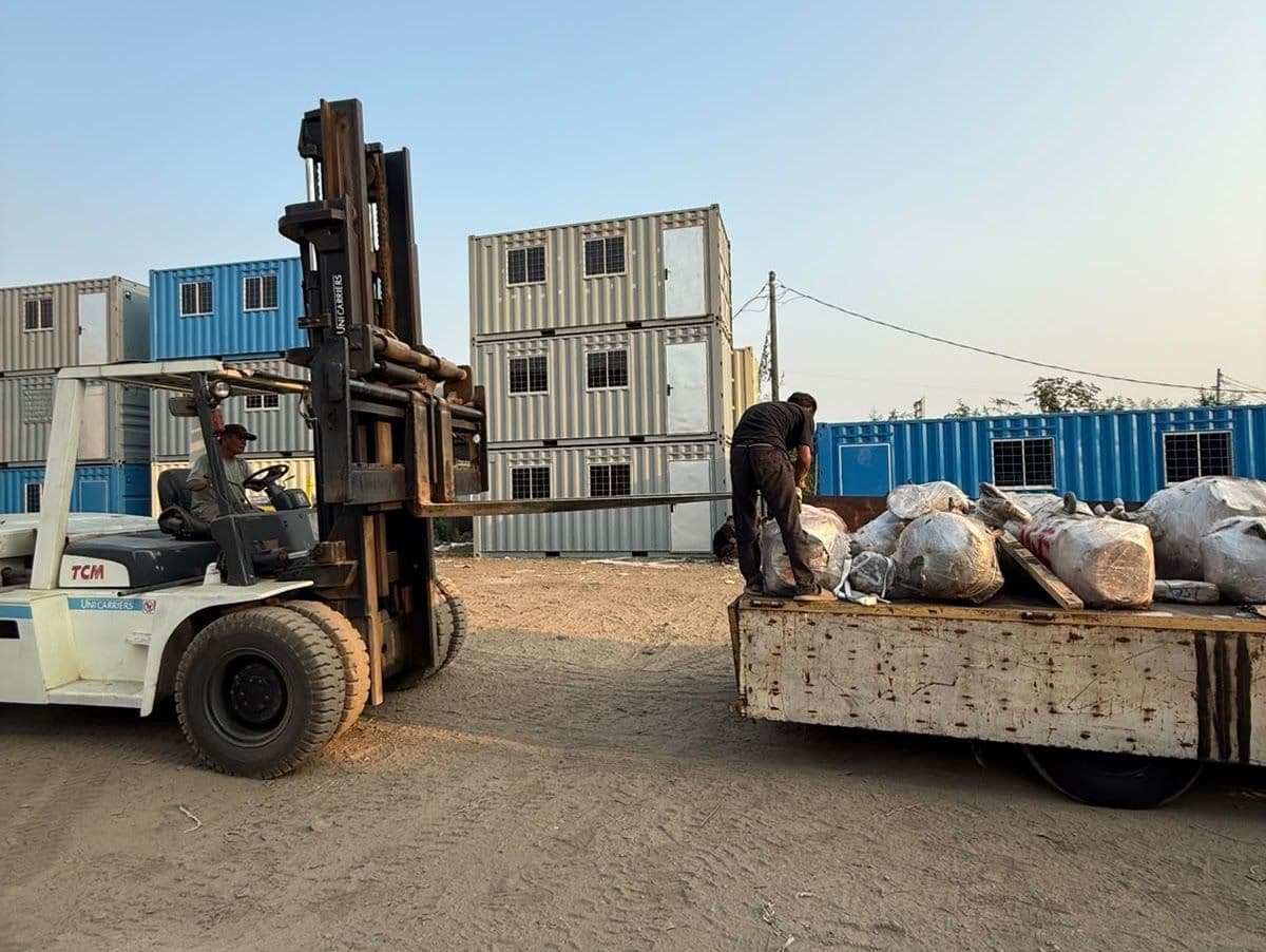 Forklift menurunkan container dari truk