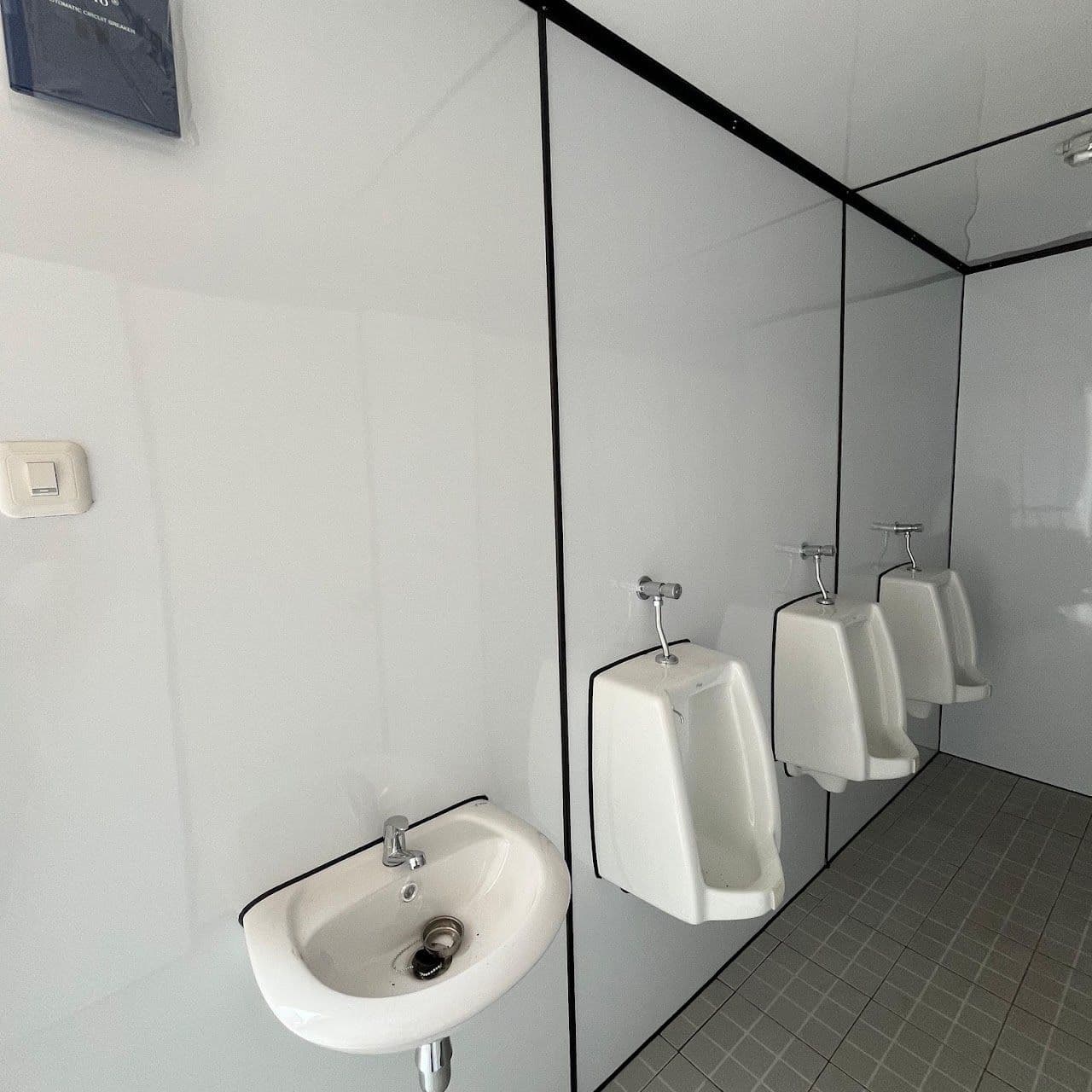 Interior toilet container dengan urinoir dan wastafel