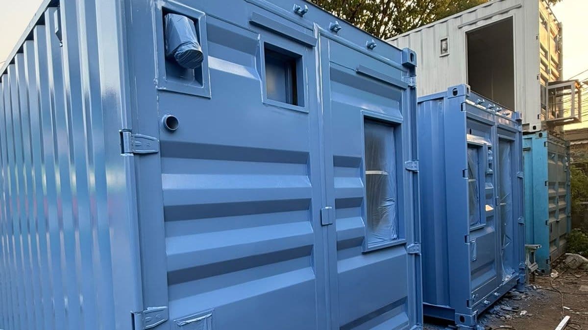 Dua unit container biru muda dengan pintu panel